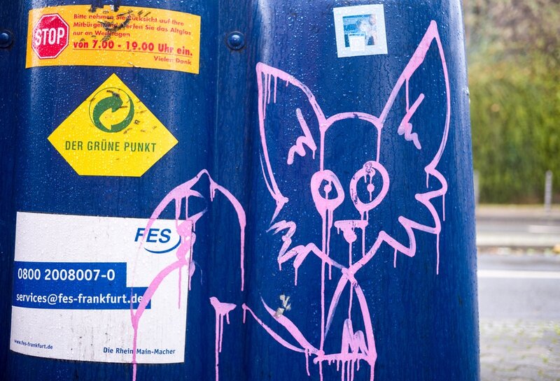 Graffiti pinke Katze auf blauem Pfosten